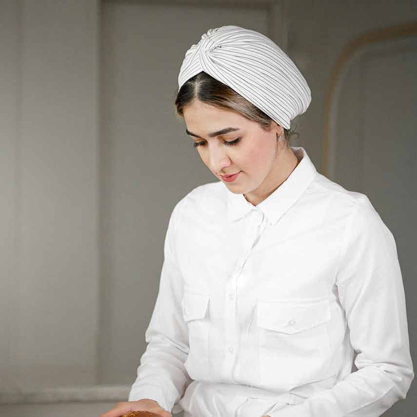 Portrait of Emily wearing a white chef outfit making cheese
